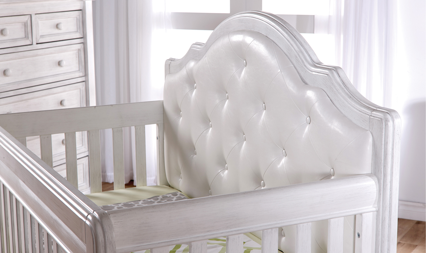The 2202 <b>Cristallo Forever Crib</b> in Vintage White. This latest addtion to the Cristallo collection features a <i>white</i> vinyl upholstered panel headboard.