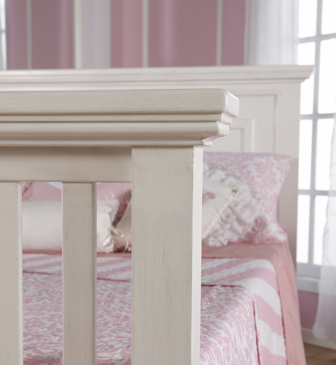 A detail of the <b>Modena Forever Crib</b>, converted into a <b>full-size bed</b>, in Vintage White.